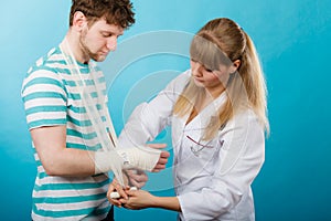 Doctor bandaging sprained wrist.