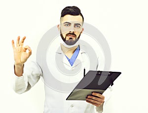 Doctor with beard holds clip folder for prescriptions