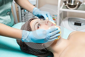 Doctor beautician cleanses skin woman with sponge. cosmetology treatment skincare face. Spa procedures