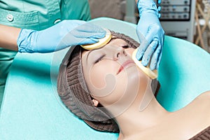 Doctor beautician cleanses skin woman with sponge. cosmetology treatment skincare face. Spa procedures