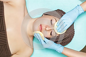 Doctor beautician cleanses skin woman with sponge. cosmetology treatment skincare face. Spa procedures