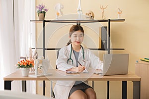 Doctor beautiful asian women sitting and working on desk using laptop and writing note at hospital,Female typing on laptop compute
