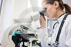 Doctor or biologist scrutinizing tissue under microscope photo