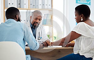 Doctor, black couple and holding hands in consultation clinic, support and comfort. Healthcare, obstetrician and man and