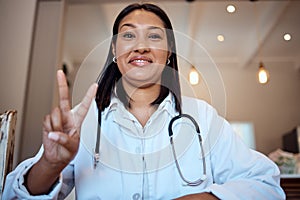 Doctor, black woman and peace sign in video call, hospital and smile with happiness, proud and medical job. Woman, nurse