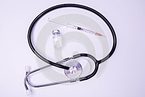 Doctor blue stethoscope for cardiac on white background with syringe.Equipment of physician for diagnose heartbeat in hospitality.