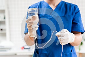 Doctor in blue uniform holding drip iv and infusion pump. Medical treatment emergency concept.. Intravenous fluid for photo