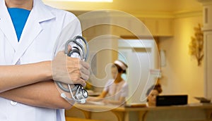 Doctor with blurred hospital counter and nurses.