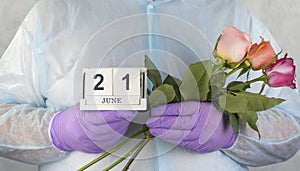 Doctor with a bouquet of flowers in his hands. medical worker in surgical gown and medical gloves