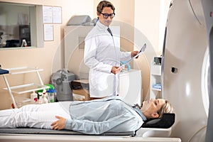 Doctor with brain CT scan looking at patient