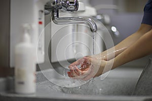 The doctor carefully washes his hands