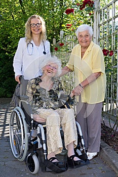 Doctor, Caregiver and Elderly Smiling at Camera