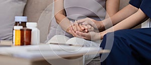 Doctor or caregiver woman holding elderly female patient hand cheer and encourage while checking health