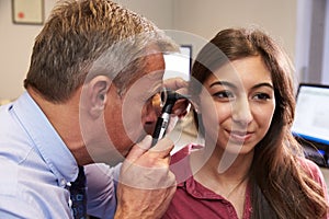 Doctor Carrying Out Ear Exam On Female Patient