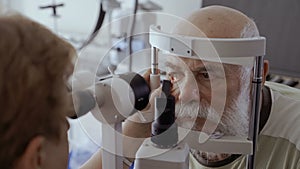 Doctor check eyesight of senior man with biomicroscope