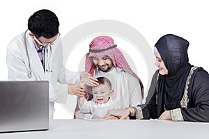 Doctor check the fever of Arabian baby