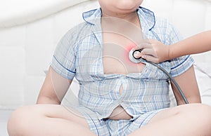 Doctor check heart by stethoscope to obese asian boy