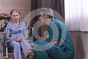 Doctor check knee of senior patient on patient Wheelchair in hospital, healthcare and medical concept