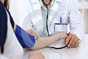 Doctor checking blood pressure of the patient, closeup. Cardiology in medicine and health care concept