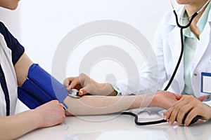 Doctor checking blood pressure of the patient, closeup. Cardiology in medicine and health care concept