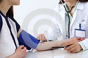 Doctor checking blood pressure of the patient, closeup. Cardiology in medicine and health care concept photo