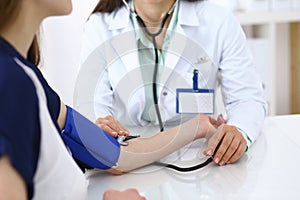 Doctor checking blood pressure of the patient, closeup. Cardiology in medicine and health care concept