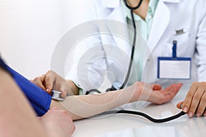 Doctor checking blood pressure of the patient, closeup. Cardiology in medicine and health care concept