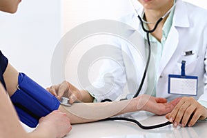 Doctor checking blood pressure of the patient, closeup. Cardiology in medicine and health care concept