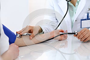 Doctor checking blood pressure of the patient, closeup. Cardiology in medicine and health care concept photo