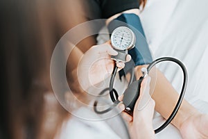 Doctor checking blood pressure of a patient with sphygmomanometer photo