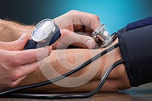 Doctor Checking Blood Pressure Of Patient At Table