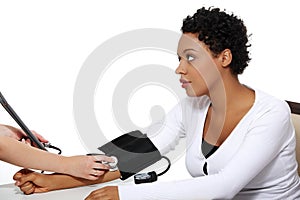 Doctor checking blood pressure of pregnant woman.