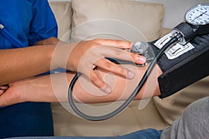 Doctor Checking Blood Pressure To A Mature Woman At Doctor`s Office