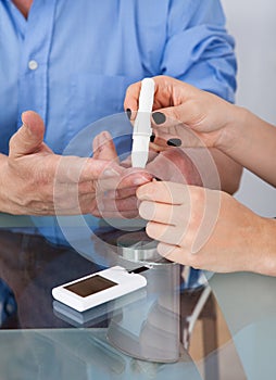 Doctor checking glucose level in diabetic patient photo