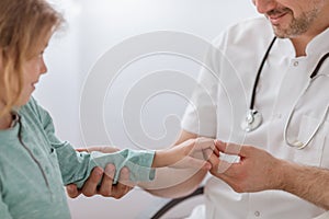 Doctor checking hand of child in the hospital