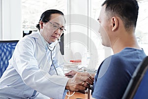 Doctor checking heartbeat of patient