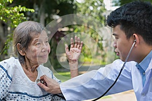 Doctor checking lung of elderly woman during homecare medical