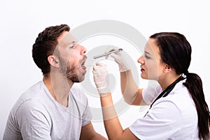 Doctor Checking Man`s Sore Throat