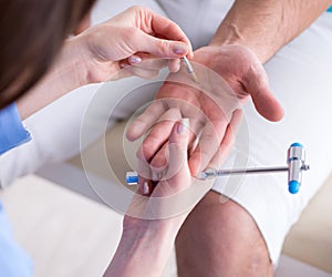 Doctor checking nerve reflexes with hammer