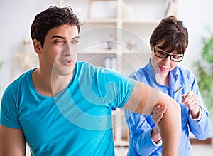 Doctor checking nerve reflexes with hammer