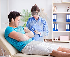 Doctor checking nerve reflexes with hammer