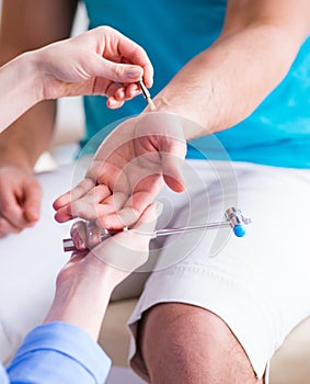 Doctor checking nerve reflexes with hammer