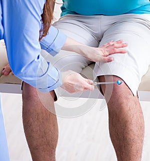 Doctor checking nerve reflexes with hammer