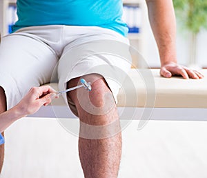 Doctor checking nerve reflexes with hammer