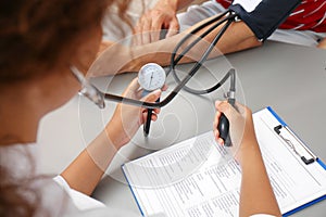 Doctor checking patient`s blood pressure