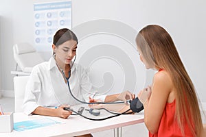 Doctor checking patient`s blood pressure at table
