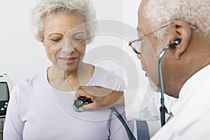 Doctor Checking Patient's Heartbeat Using Stethoscope photo