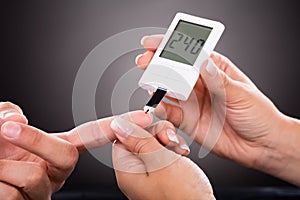 Doctor Checking Patient`s Sugar Level With Glucometer photo