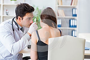 The doctor checking patients ear during medical examination