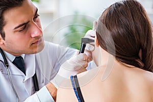 The doctor checking patients ear during medical examination